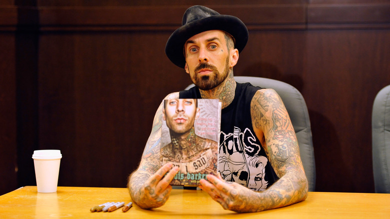 Travis Barker holding his memoir