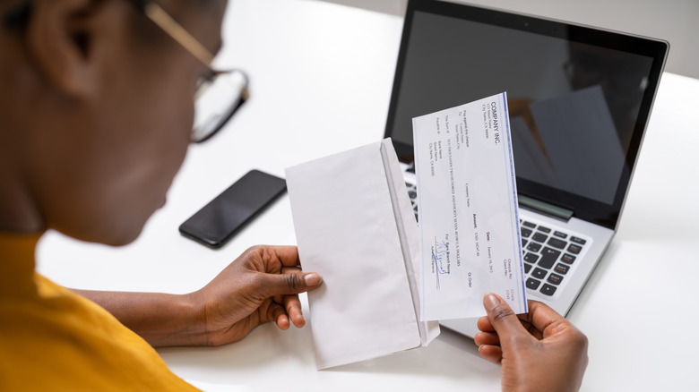 Woman holding a paycheck 