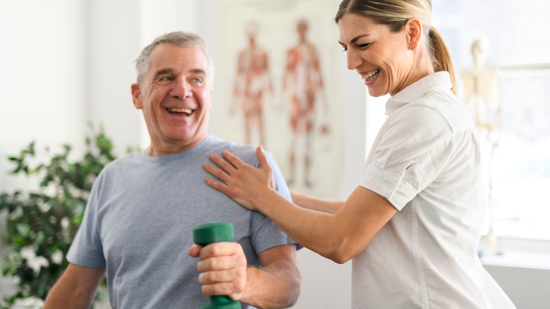 physical therapist with older patient