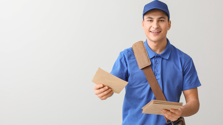 A postal worker holding mail