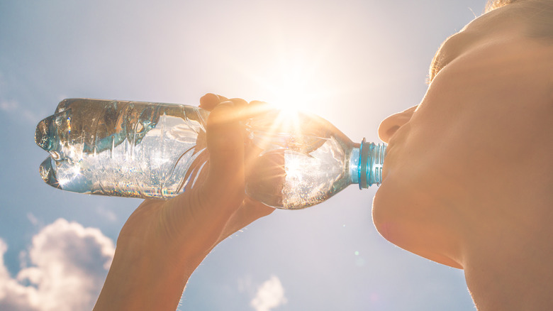 Woman drinking water in sunshine