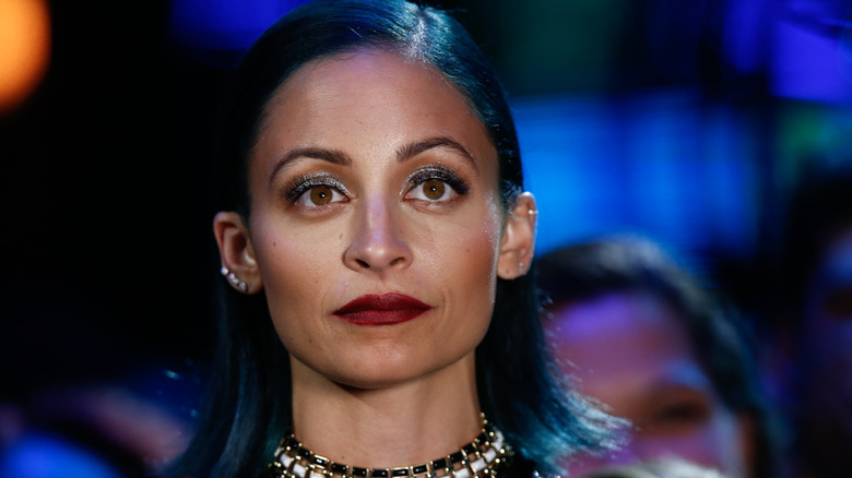 Close up of Nicole Richie with dark blue hair and a red lip 