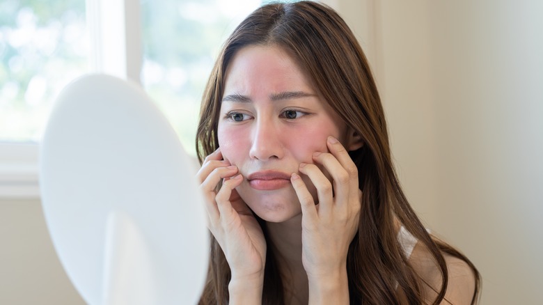 sad woman touches her red face