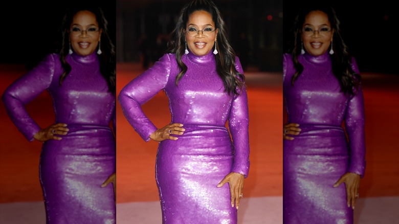 Oprah posing in a purple sequin dress