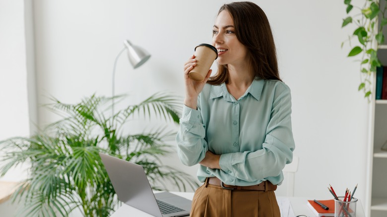 Woman in blue drinking coffee