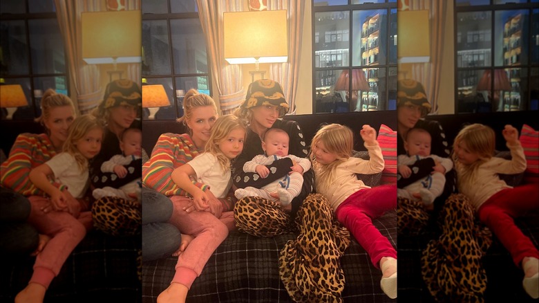 Nicky Hilton Rothschild, her children, and Paris Hilton sitting together on a couch 