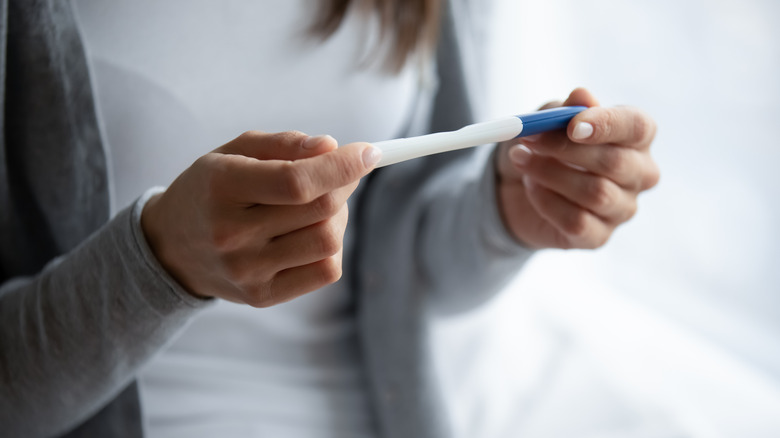 woman holding pregnancy test