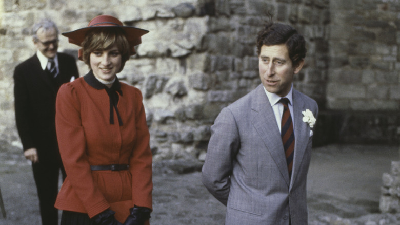 Prince Charles and Princess Diana outside a stone building