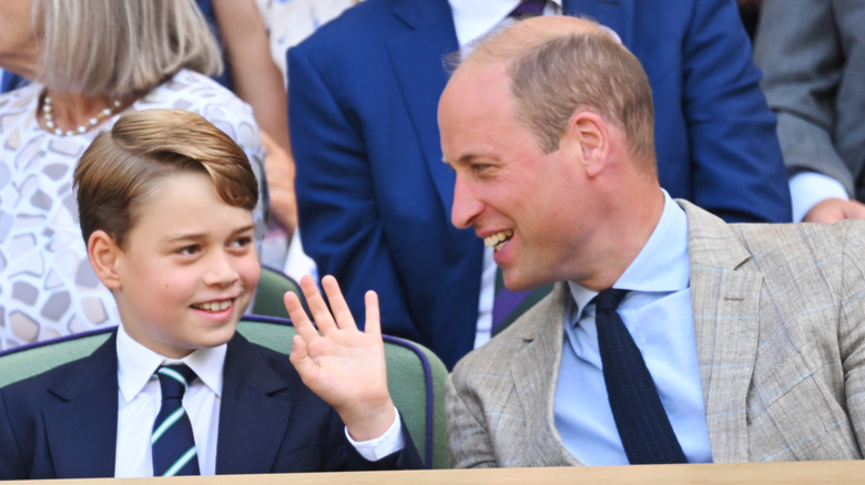 Prince George waves next to Prince William, smiling 