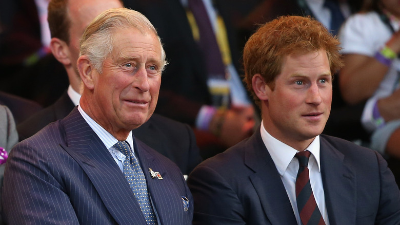 Prince Harry sits next to Prince Charles at an event 