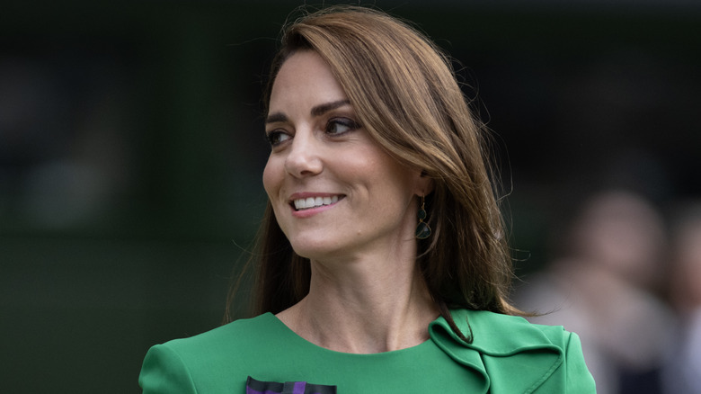 Kate Middleton smiling and looking right at Wimbledon