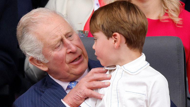 King Charles holding Prince Louis on his lap and talking with him