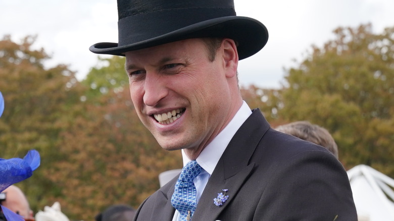 Prince William smiling and wearing forget-me-nots