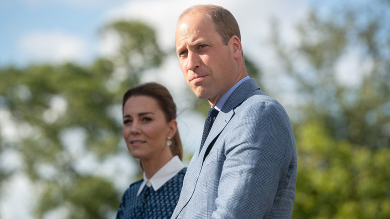 Prince William pictured with Kate Middleton standing in the background