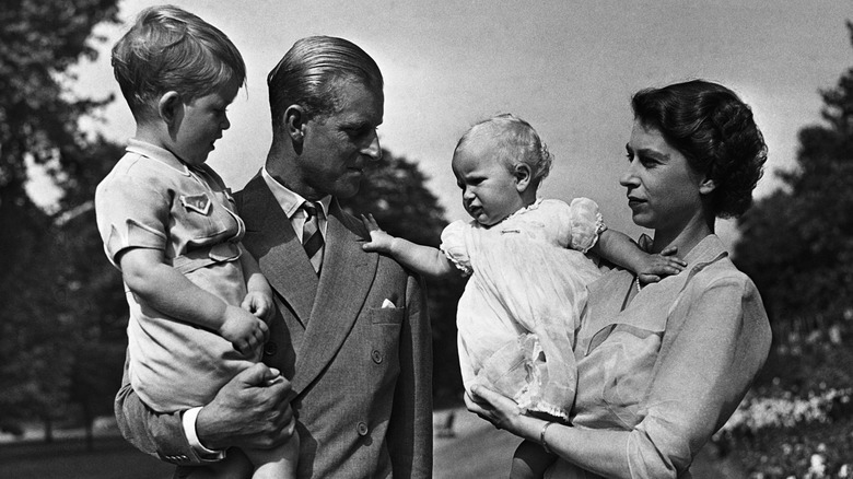 Queen Elizabeth and Prince Philip holding a young Charles and Anne