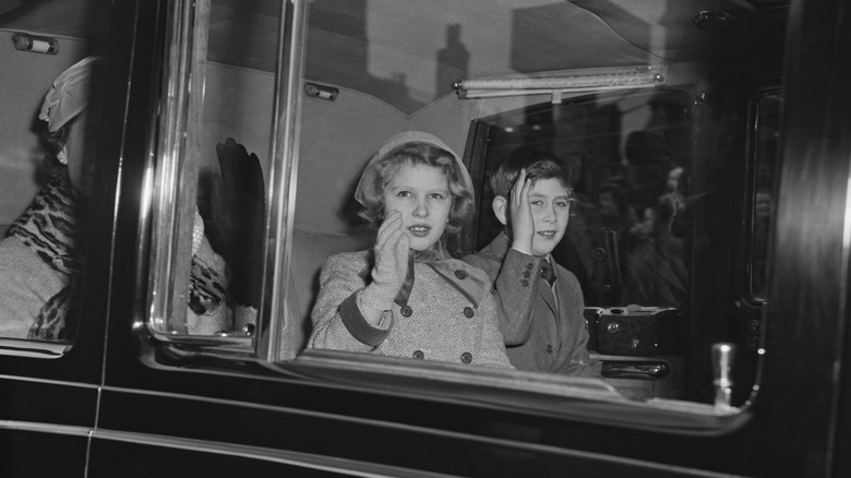 Young Princess Anne and King Charles waving in car