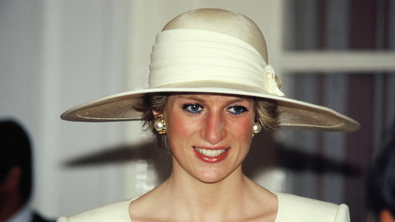 Princess Diana wearing a cream colored hat