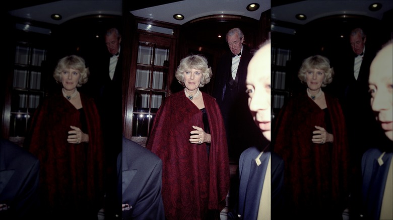 Queen Camilla entering party in red shawl