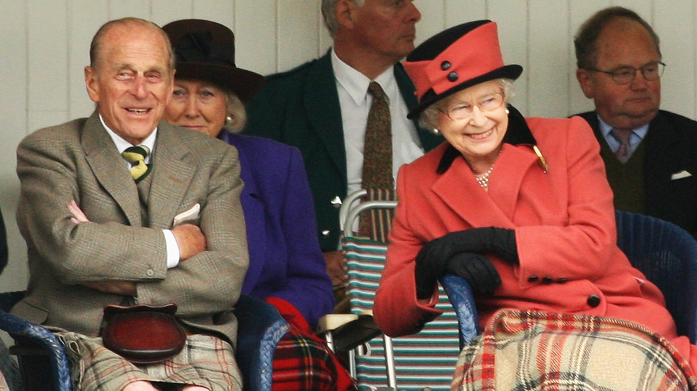 Queen Elizabeth and Prince Philip laughing outdoors