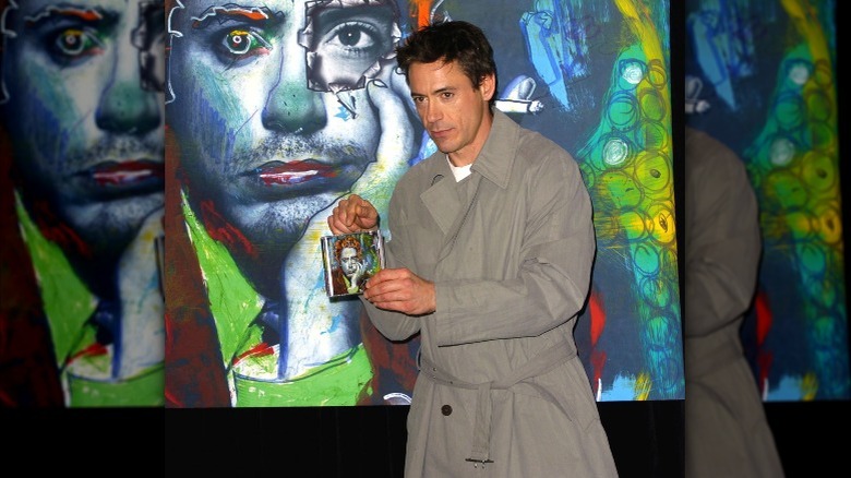 Robert downey jr. holding his album "The futurist" at a signing