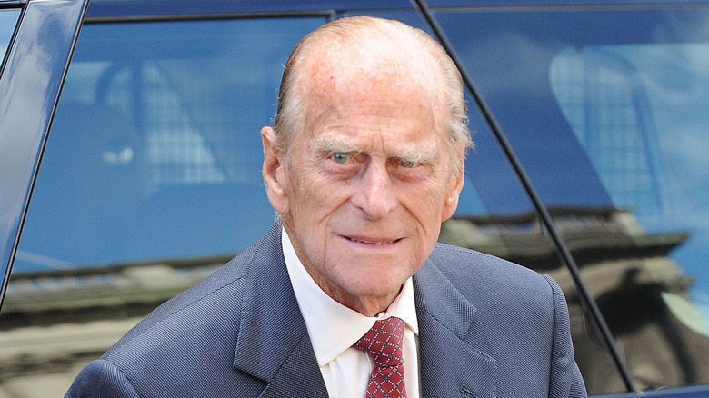 Prince Philip leaving a car in a suit