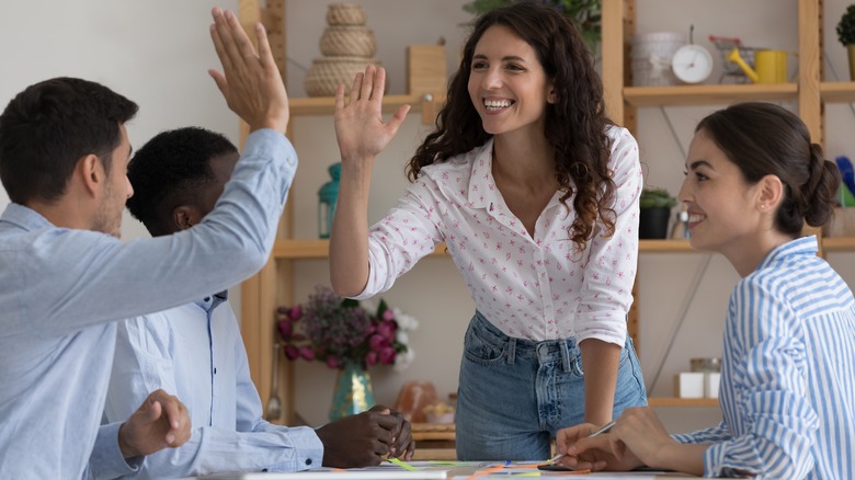 employees meeting smiling high-fiving