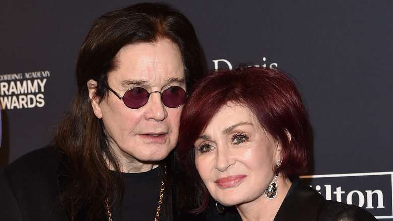 Sharon Osbourne leaning on Ozzy Osbourne