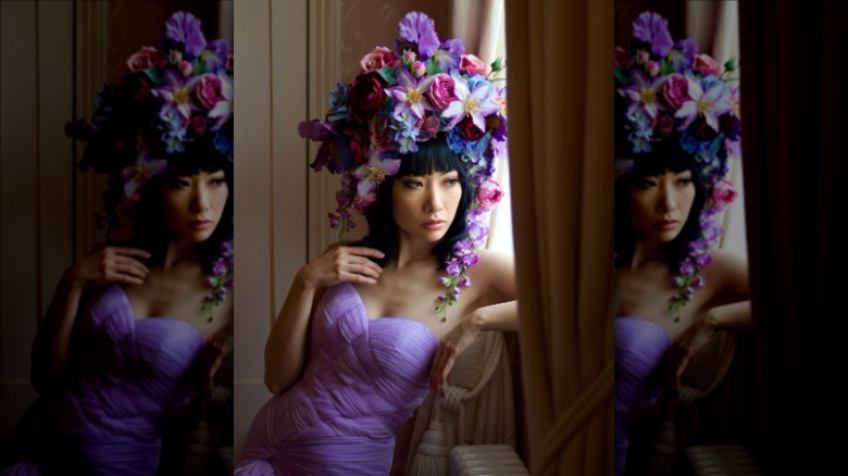 Model wearing purple dress and flower headpiece