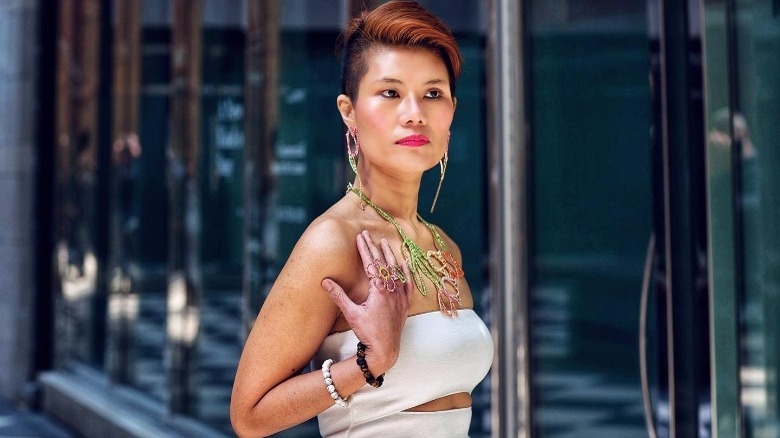 Woman wearing beaded flower necklace and dress