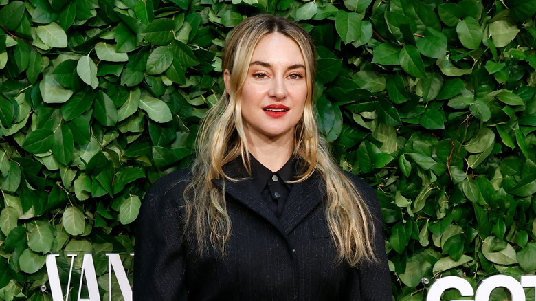 Shailene Woodley wearing black in front of leafy background