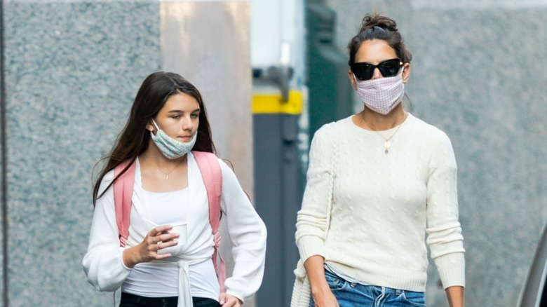 Suri Cruise and Katie Holmes walking in masks