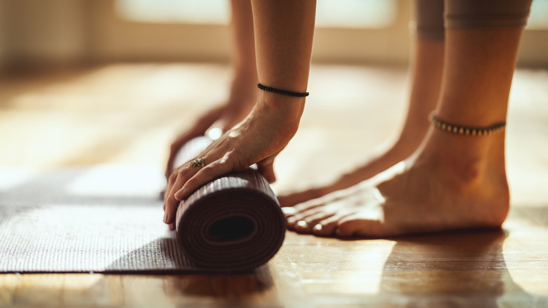 Woman rolling a yoga mat