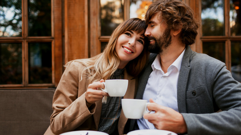 a couple cuddling with coffee