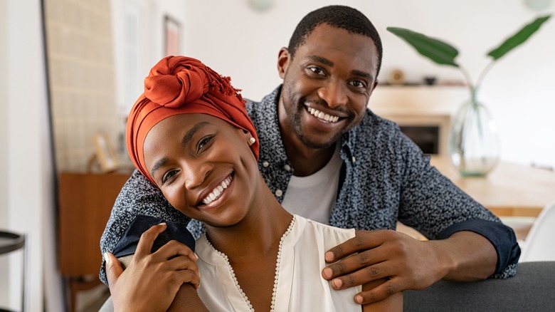 A couple embracing and smiling. 