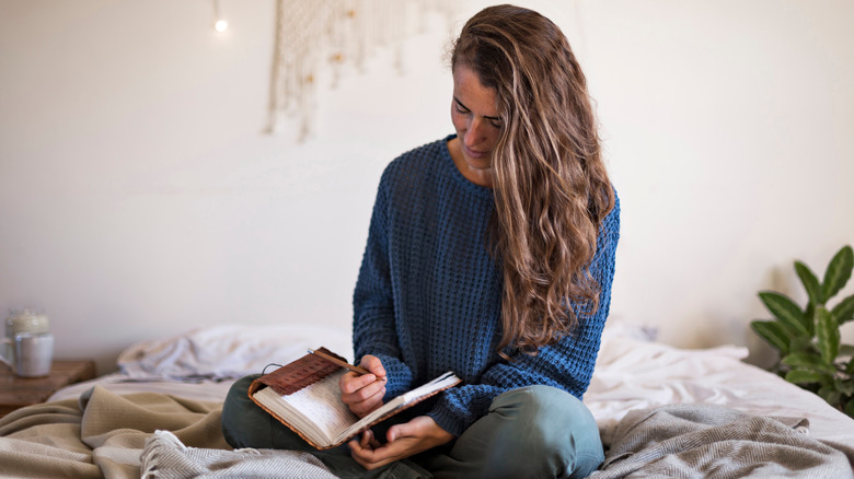 A woman writing in a journal.  