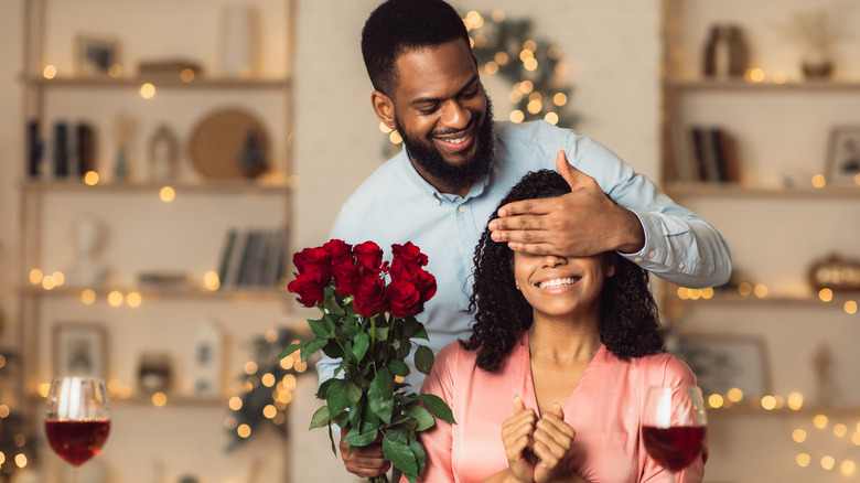 A man surprises a woman with roses 