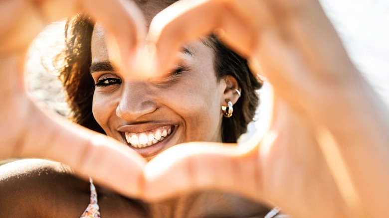 A woman making a heart with her hands