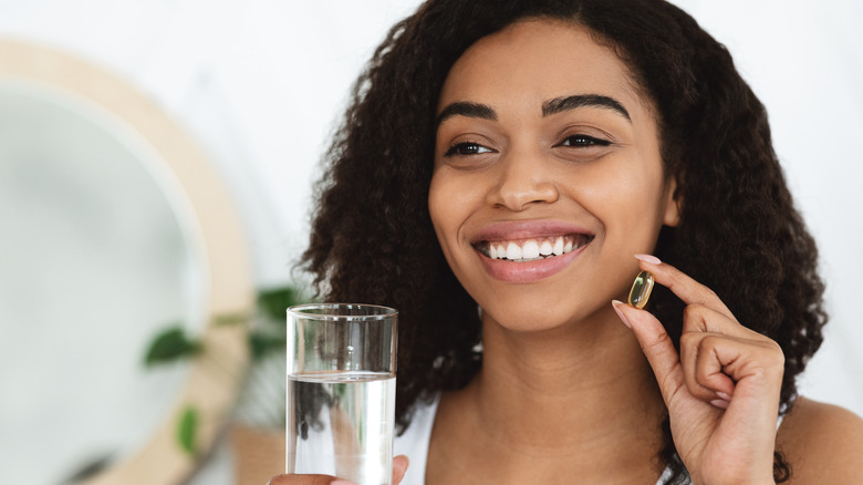 A woman taking vitamins. 