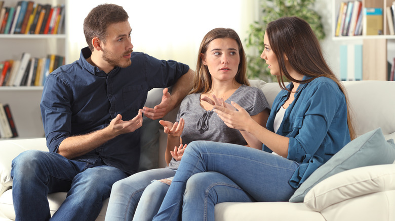 three people talking on couch