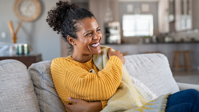 A woman relaxing with blanket on sofa