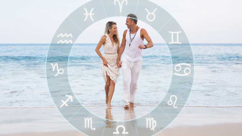 Zodiac wheel sign hologram imposed on beach couple