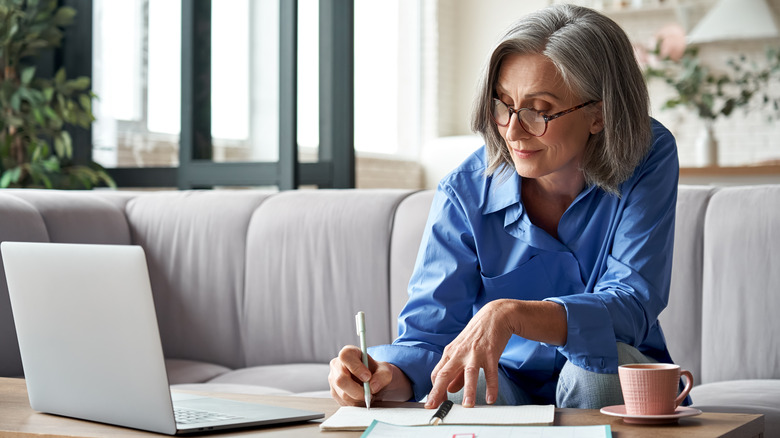 A woman planning in her notebook and laptop