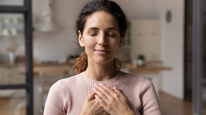 Woman holding hands to chest to express gratitude 