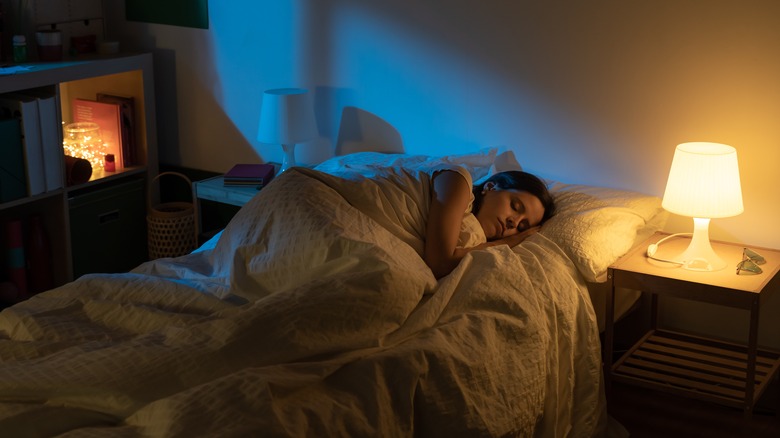 Scorpio woman resting with twinkle lights in bedroom