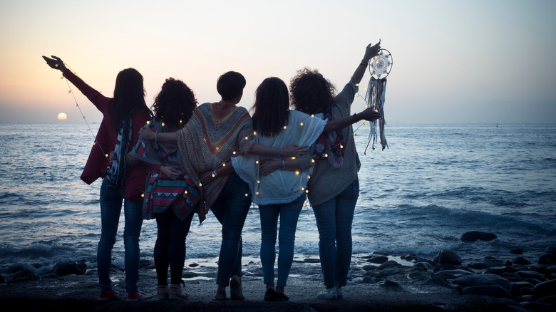 Friends standing together on the beach at night