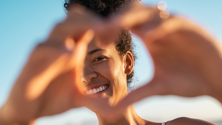 a woman making a heart shape