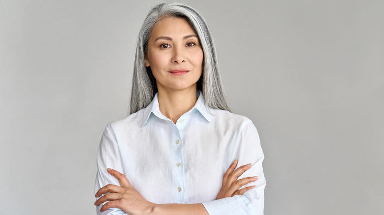 A woman posing for a photo with her arms crossed. 