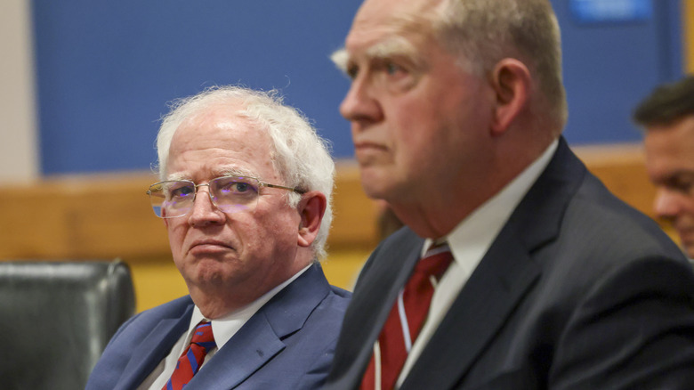 John Eastman looking at camera, sitting next to lawyer