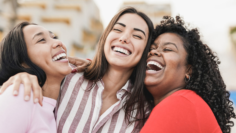 Three women smiling together. 