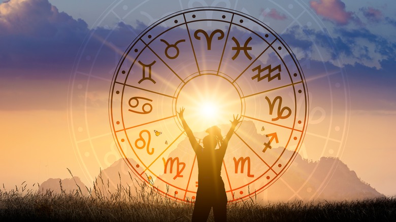 zodiac wheel in front of a rising sun 